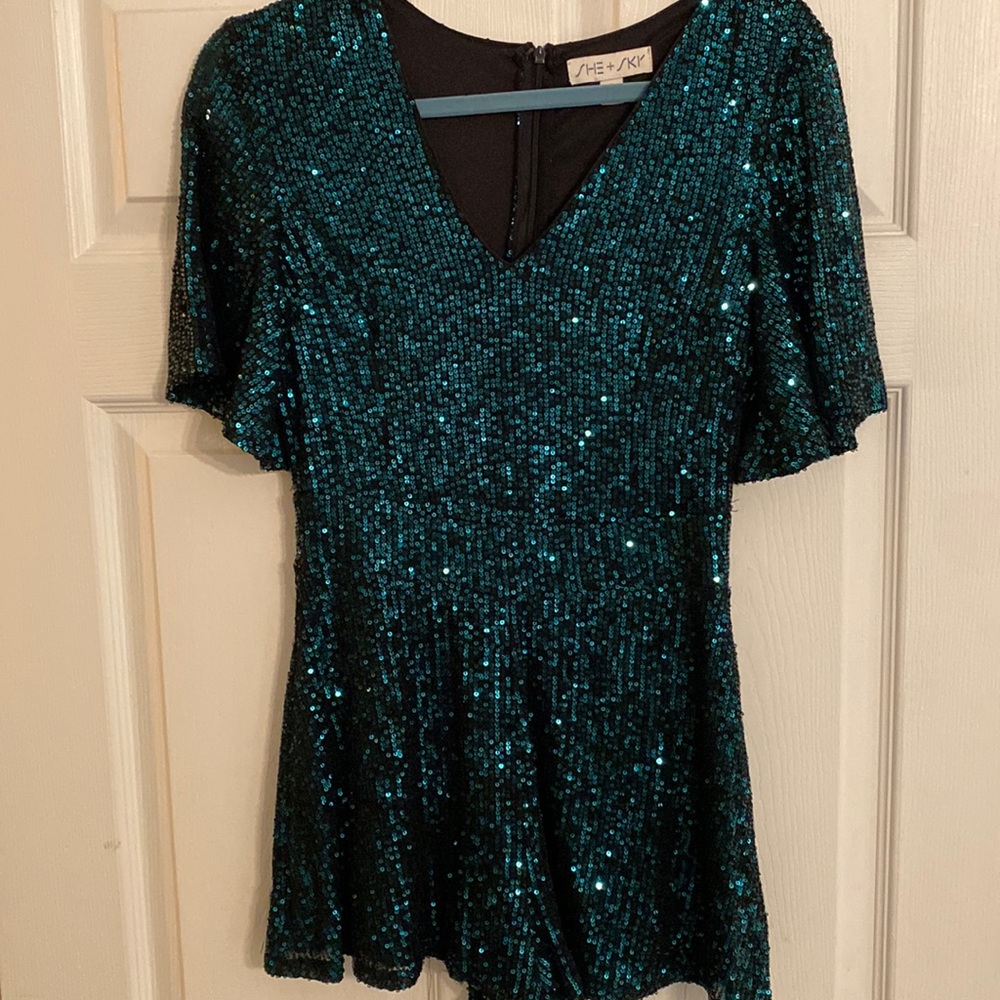 Gorgeous dark green sparkle short romper. Zippered back and modest v-neck.